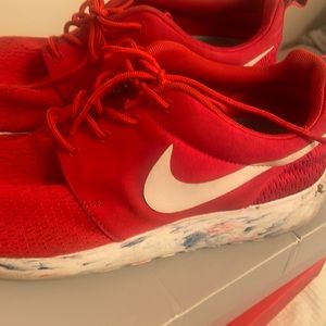 Red Nike shoes with skittle bottoms